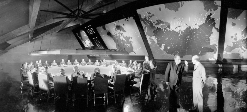 War Room con tavolo circolare e mappe strategiche globali nel film Dr. Strangelove di Stanley Kubrick