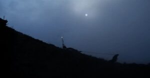 Un uomo trascina una slitta in un paesaggio oscuro nel cortometraggio Juggernaut.